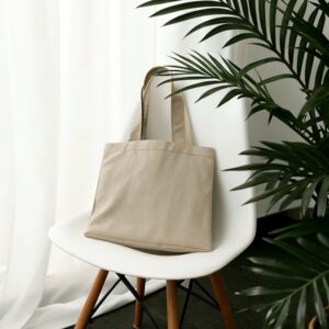 A bag sitting on top of a white chair next to a plant